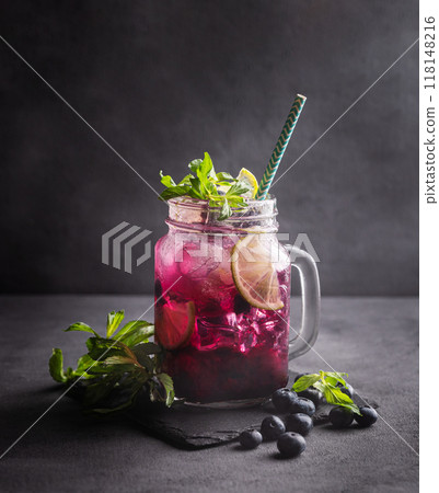Refreshing blueberry mojito or lemonade with lime, mint and ice on a dark background. 118148216