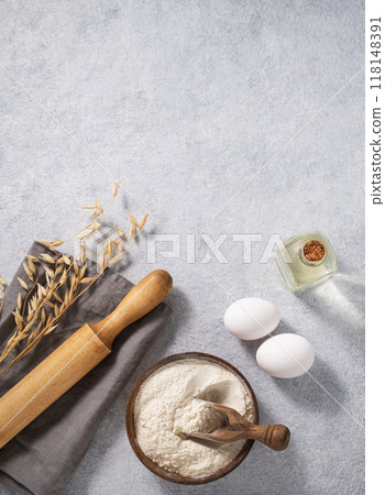 Oatmeal in a wooden bowl with eggs, oli and rolling pin on a blue background. Oatmeal in a wooden bowl with eggs, oli and rolling pin on a blue background. 118148391