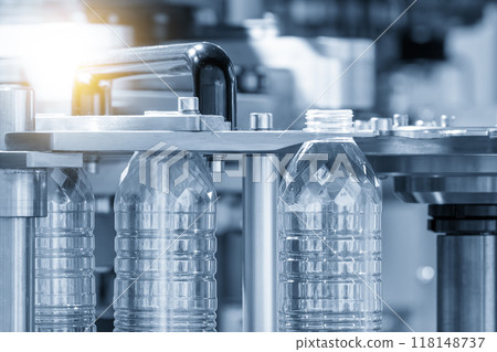 The drinking water bottle manufacturing process by blow mold machine in the light blue scene with lighting effect. 118148737