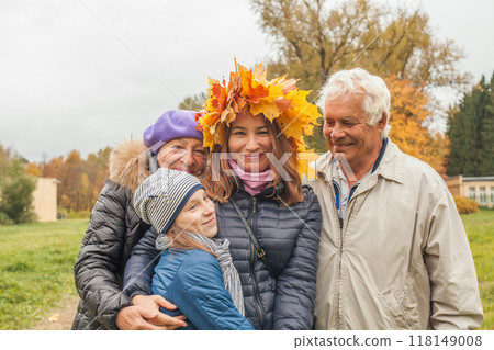 Autumn family portrait. Senior man and woman, mid adult woman and child girl outdoor 118149008