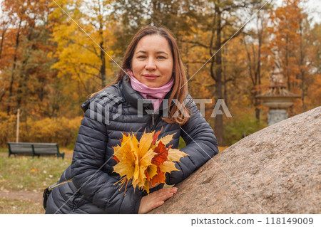 Brunette woman with yellow leaves outdoor on autumn background, portrait Brunette woman with yellow leaves outdoor on autumn background, portrait 118149009