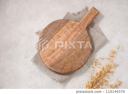 Empty wooden board on light texture background with dry branch and kitchen towel.  118149370