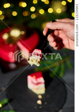 A Person Cutting a Slice of Vibrant Layered Cake on a Black Plate Adorned With Festive Decorations A Person Cutting a Slice of Vibrant Layered Cake on a Black Plate Adorned With Festive Decorations 118150901