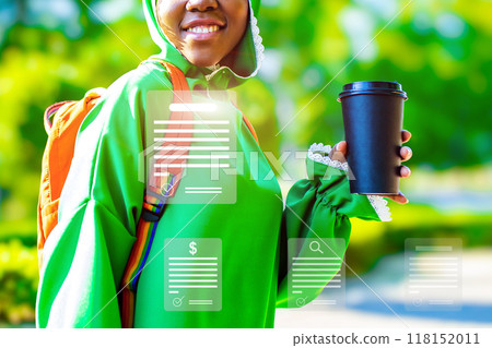 A woman is holding a black coffee cup and wearing a green jacket A woman is holding a black coffee cup and wearing a green jacket 118152011