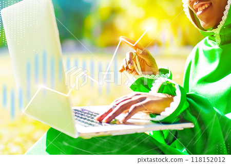 A woman is sitting on the ground and using a laptop A woman is sitting on the ground and using a laptop 118152012