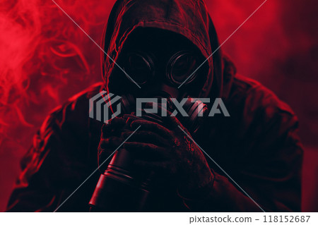 A person wearing a gas mask with a red light, in a horror-style setting with a dark background. 118152687