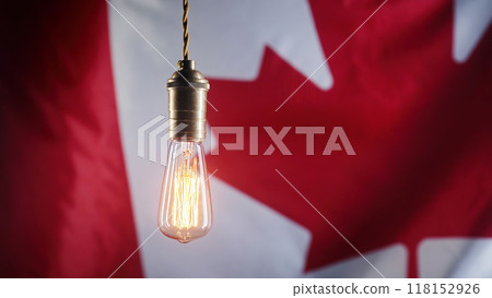 Classic antique Edison Tungsten filament lamp on waving canadian flag background. Creative idea, realization, discovery, eureka Classic antique Edison Tungsten filament lamp on waving canadian flag background. Creative idea, realization, discovery, eureka 118152926