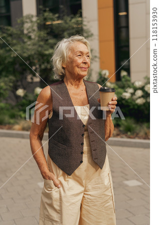 A Stylish Elderly Woman Enjoys Sipping Her Coffee Relaxingly Outdoors in the Sunlight A Stylish Elderly Woman Enjoys Sipping Her Coffee Relaxingly Outdoors in the Sunlight 118153930