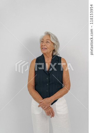 An Elegant Senior Woman Dressed in Casual Attire Who is Smiling Cheerfully and Gracefully 118153954