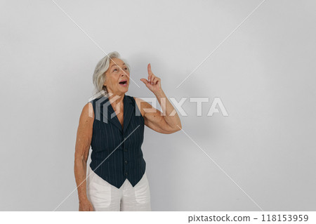 A Senior Woman is Gesturing with Enthusiasm and Joy in a Bright Studio Environment A Senior Woman is Gesturing with Enthusiasm and Joy in a Bright Studio Environment 118153959