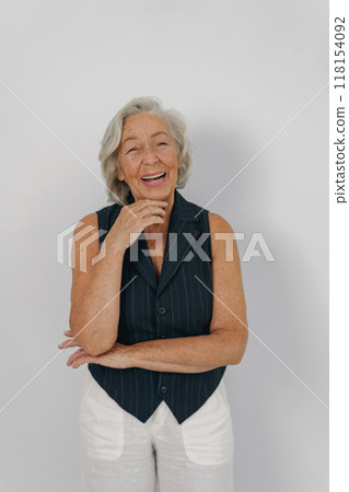 A Joyful Elderly Woman in a Stylish Outfit Radiating Confidence While Engaging in Her Surroundings 118154092