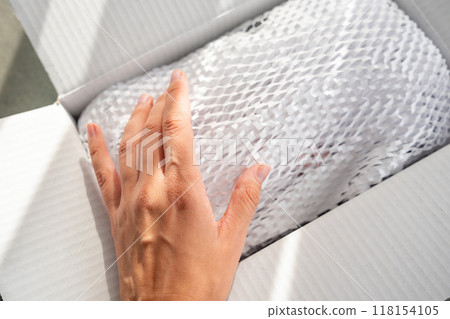 Corrugated white paper for safe transportation, in which the goods brought by the courier delivery service are wrapped, environmental packaging concept Corrugated white paper for safe transportation, in which the goods brought by the courier delivery service are wrapped, environmental packaging concept 118154105