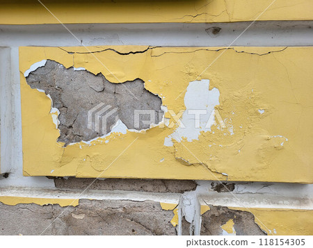 Damage and cracks on the yellow facade crumbled plaster and paint. Damage and cracks on the yellow facade crumbled plaster and paint. 118154305