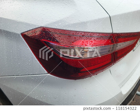 Red taillight of a white car with raindrops. 118154322