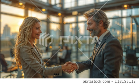 A man and woman shaking hands in a bright modern office setting, sealing a business deal 118155112