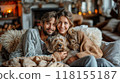 A couple relaxing with their dog, sitting together on a cozy couch at home 118155187