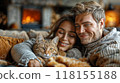 A couple relaxing on the couch with their cat, enjoying a cozy evening at home 118155188