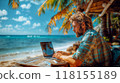 A freelancer working on a laptop on a tropical beach, surrounded by palm trees and ocean waves 118155189