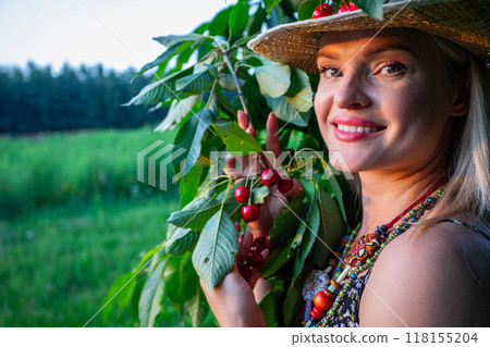 Smiling and pretty woman posing with cherry tree during golden hour Smiling and pretty woman posing with cherry tree during golden hour 118155204