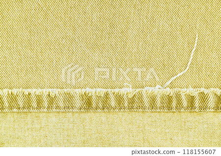 Yellow denim jeans pants edge, ripped stich on jean fabric background, close up, macro. 118155607