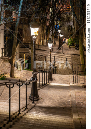 The charming staircase in Montmartre is softly illuminated by vintage street lamps, inviting evening strolls through Paris's artistic neighborhood. 118155749