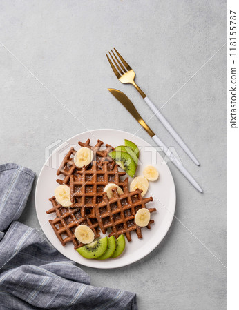 A freshly prepared chocolate waffles with kiwi, blueberries and banana slices A freshly prepared chocolate waffles with kiwi, blueberries and banana slices 118155787