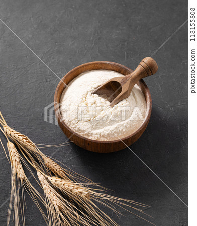 Wheat flour and dry branch on a dark background. Organic baking ingredients. Wheat flour and dry branch on a dark background. Organic baking ingredients. 118155808