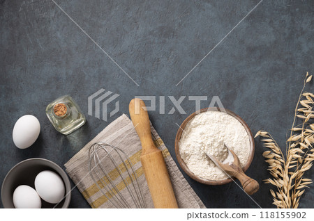 Oatmeal in a wooden bowl with eggs, rolling pin and oli on a dark blue background. Oatmeal in a wooden bowl with eggs, rolling pin and oli on a dark blue background. 118155902