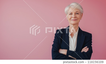 Confident Elderly Businesswoman Standing with Crossed Arms Against a Pink Background for Professional Use 118156109