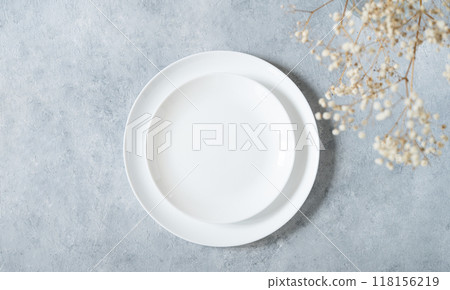 Table setting in a minimalist style with white plate and a bouquet of gypsophila Table setting in a minimalist style with white plate and a bouquet of gypsophila 118156219