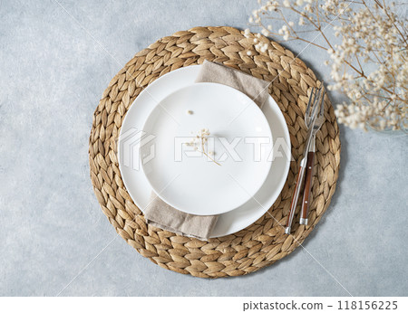 Table setting in a minimalist style with white plate and a bouquet of gypsophila Table setting in a minimalist style with white plate and a bouquet of gypsophila 118156225