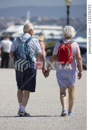Senior tourist couple holding hands and walking in the city 118156291