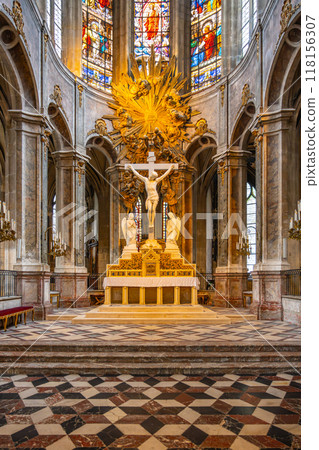 The interior of the Church of Saint-Merri features beautiful stained glass windows and a striking altar adorned with sculptures and a large crucifix, showcasing intricate architectural details. 118156307