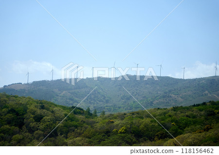 Wind turbines for natural energy generation standing on top of a mountain and blue sky 118156462