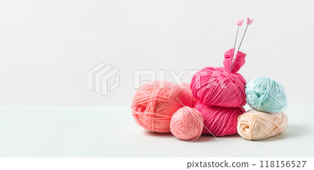 Pink, yellow, blue knitted wool on gray background with knitting needles for knitting warm clothes and hobbies needlework 118156527