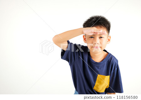 Searching concept. Asian young boy kid looking far away with hand over head at studio shot isolated on white background, Portrait of Happy primary child looking at distance with eyes shaded 118156580