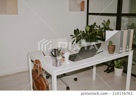 Office supplies and black laptop on white wooden table at home Office supplies and black laptop on white wooden table at home 118156761