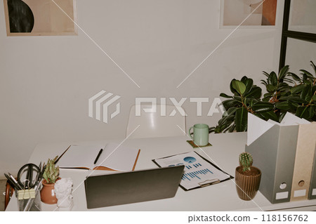 High angle shot of white table with laptop, office supplies and papers High angle shot of white table with laptop, office supplies and papers 118156762