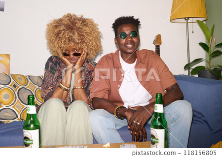 Two best friends sitting on comfort sofa in living room during party time while posing for photo 118156805