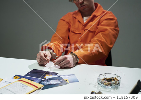 Wearing Orange Jumpsuit Holding Handcuffs 118157309