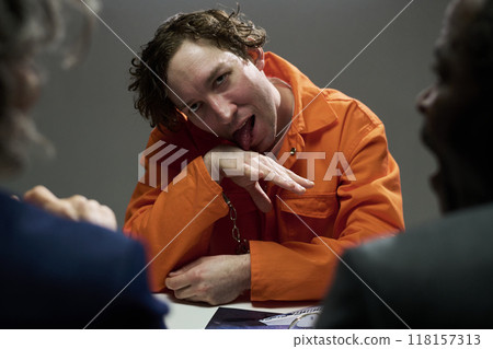 Expressing Defiance in Orange Jumpsuit while Seated 118157313