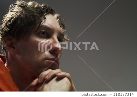 Pensive Man Resting Chin on Hands in Thoughtful Pose Pensive Man Resting Chin on Hands in Thoughtful Pose 118157314