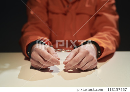 Handcuffed Individual Wearing Orange Jumpsuit in Custody Handcuffed Individual Wearing Orange Jumpsuit in Custody 118157367