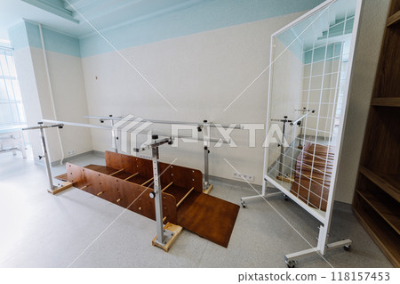 Rehabilitation equipment room with parallel bars and exercise balls for physical therapy sessions Rehabilitation equipment room with parallel bars and exercise balls for physical therapy sessions 118157453