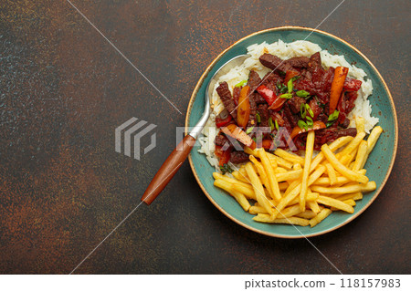Lomo saltado, traditional Peruvian dish, with french fries served on a plate with rice, space for text 118157983