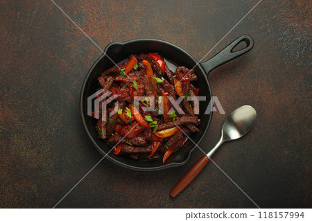 Lomo saltado, beef and red pepper stir fry cooking in cast iron pan, traditional Peruvian dish Lomo saltado, beef and red pepper stir fry cooking in cast iron pan, traditional Peruvian dish 118157994