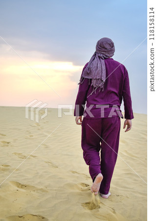 Back view Mature Masculine Spanish model walking through desert at sunset calm 118158114