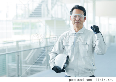 An engineer wearing protective glasses making a fist pump 118159329