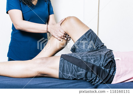 Female physiotherapist checking patient leg 118160131