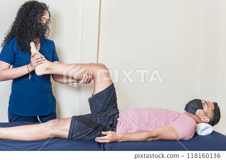 Orthopedic specialist helping patient with leg injury 118160136